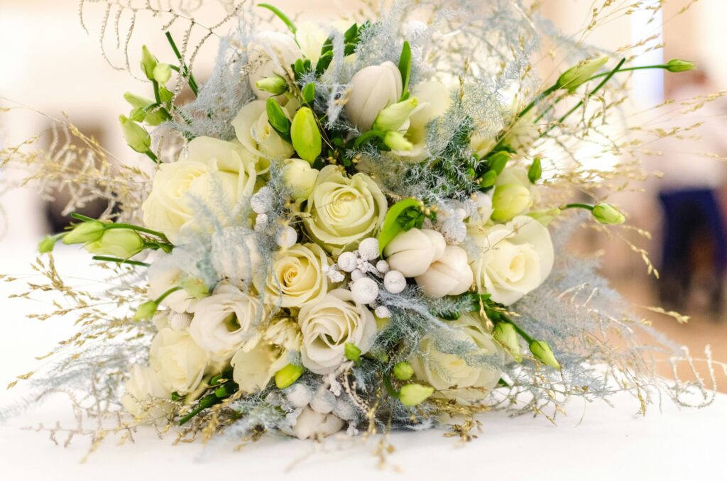 Wedding bouquet featuring white roses, green buds, and decorative foliage, symbolizing romance and elegance for Las Vegas weddings.